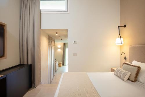 a bedroom with a white bed and a window at Mangia's Sardinia Resort - NEW OPENING in Santa Teresa Gallura