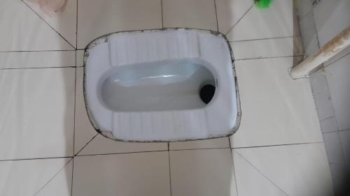 a white urinal on a white tiled wall at Holy Hills Homestay in Zirakpur