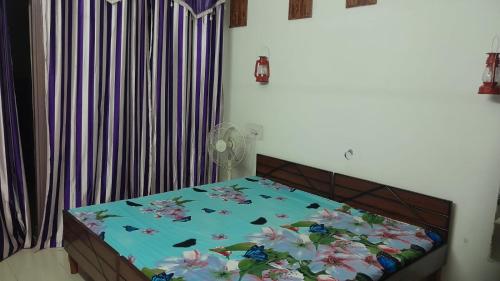 a bedroom with a bed with flowers on it at Holy Hills Homestay in Zirakpur