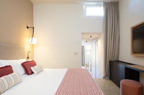 a hotel room with a bed and a flat screen tv at Mangia's Sardinia Resort - NEW OPENING in Santa Teresa Gallura