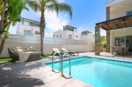 a swimming pool in the backyard of a house at Villa Anastasia - Fig Tree Bay Area in Protaras