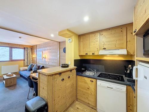 une cuisine avec des placards en bois et un salon dans l'établissement Les Menuires - 2 pièces 4/5 pers - 42m² - Balcons - Ski aux pieds - Rés. Aconit - FR-1-178-294, aux Menuires