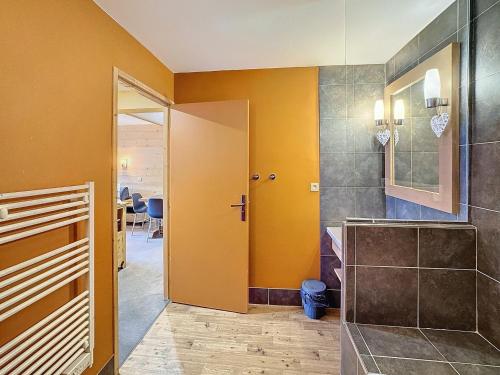 La salle de bains est pourvue d'une douche à l'italienne et de murs jaunes. dans l'établissement Les Menuires - 2 pièces 4/5 pers - 42m² - Balcons - Ski aux pieds - Rés. Aconit - FR-1-178-294, aux Menuires