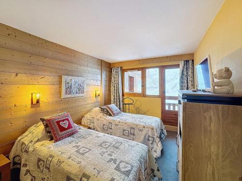 deux lits dans une chambre aux murs en bois dans l'établissement Les Menuires - 2 pièces 4/5 pers - 42m² - Balcons - Ski aux pieds - Rés. Aconit - FR-1-178-294, aux Menuires