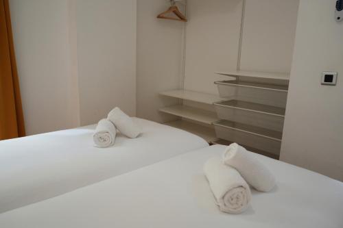 a white bed with two towels on top of it at Tgna Lluria 11 in Tarragona