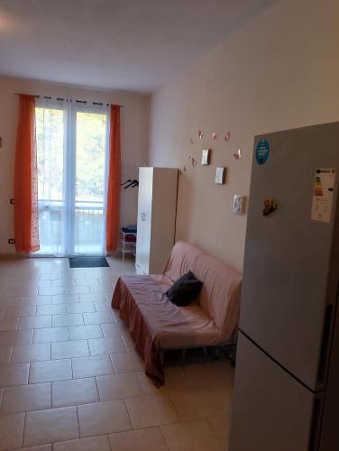 a kitchen with a refrigerator and a bed in it at La casa nella Valle in Monti di Licciana Nardi
