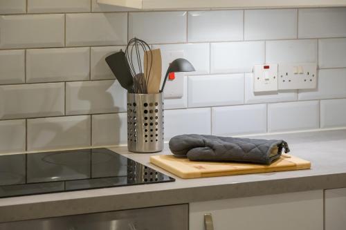 una encimera con tabla de cortar y utensilios de cocina en Belfast City apartment with free parking!, en Belfast