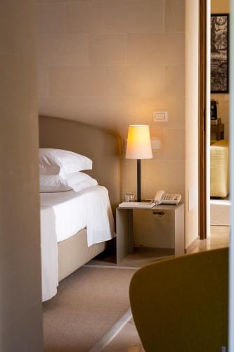 a bedroom with a bed and a desk with a lamp at La Fiermontina Luxury Home Hotel in Lecce