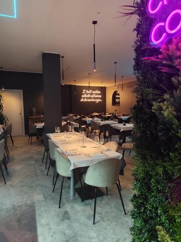 a restaurant with white tables and chairs and purple lights at Central in Casarile