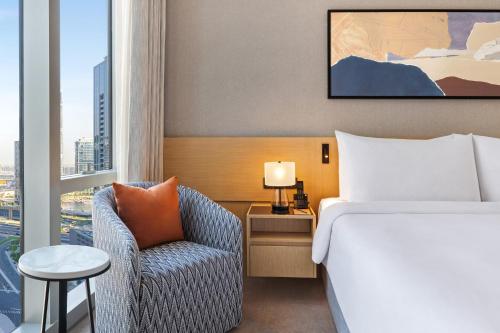 a hotel room with a bed and a chair and a window at Vida Dubai Mall in Dubai