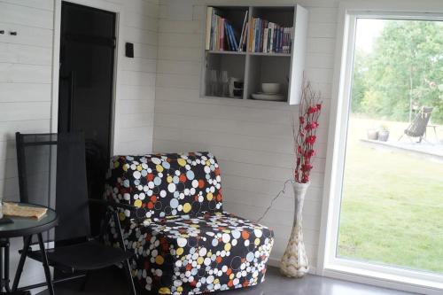 a chair in a room with a vase and a window at Nybyggt -med spabad, bastu och nära stor badstrand in Kungsör