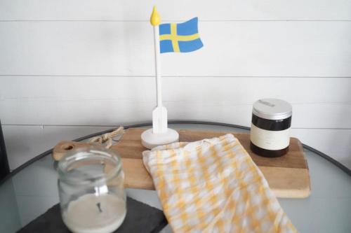 a glass table with a candle and a flag on it at Nybyggt -med spabad, bastu och nära stor badstrand in Kungsör