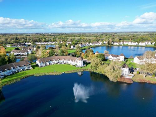 an aerial view of a home on a lake at Luxury Kingfisher Lodge, Isis Lake, within the Cotswold Waterpark in Cirencester