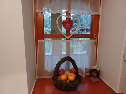 a basket of fruit on a table next to a window at Tulipán Ház in Bodony