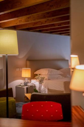 a hotel room with a bed and a red chair at La Fiermontina Luxury Home Hotel in Lecce