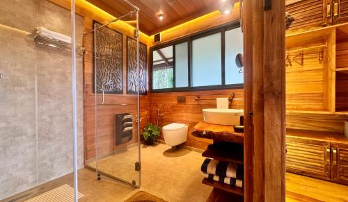 a bathroom with a toilet and a sink and a shower at Tranquil Resort - Blusalzz Collection, Wayanad - Kerala in Ambalavayal