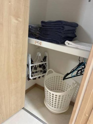 a white basket sitting on a shelf in a closet at Disney11min Makuhari Messe14min 2 free parking in Funabashi