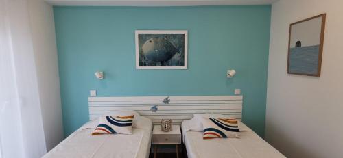 two beds in a room with blue walls at Apartamento Varanda do Sol in Monte Gordo