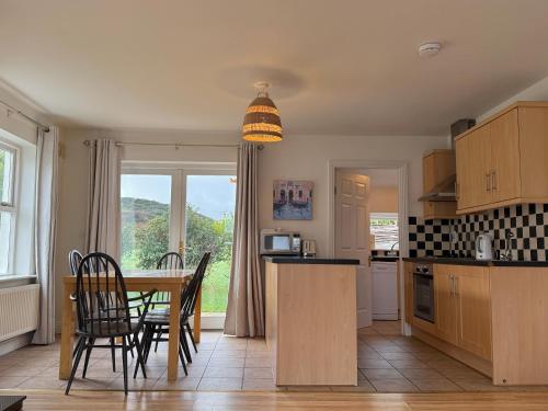 a kitchen with a table and chairs and a dining room at Doolin Village Lodges in Doolin