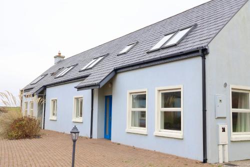 a white house with solar panels on the roof at Doolin Village Lodges in Doolin
