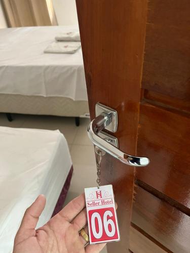 Eine Person öffnet eine Tür mit einem Schlüssel. in der Unterkunft Seller Hotel in Sobral