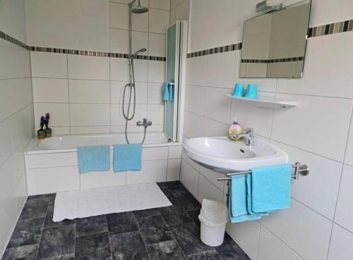 a bathroom with a sink and a tub and a mirror at Ferienhaus an der Saline in Bad Karlshafen