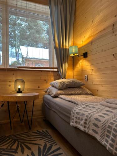 a bedroom with a bed and a table and a window at Połoninka Pokoje in Ustrzyki Górne