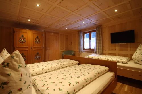 a bedroom with two beds and a television in it at Vendula Montafon in Partenen