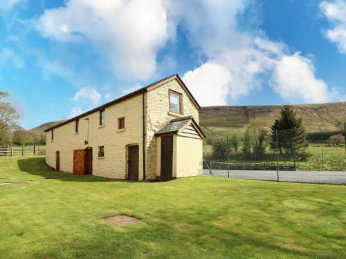 an old stone building on a field of grass at Ty Hir at Blaenbrynich Farm in Brecon