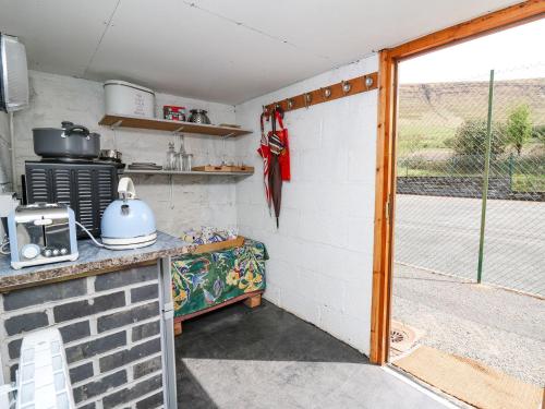 a kitchen with a door open to a patio at Ty Hir at Blaenbrynich Farm in Brecon