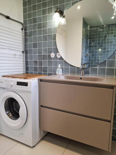 a bathroom with a washing machine and a sink at Kerastrobel in Crozon