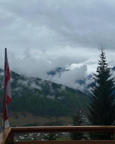 a view of a mountain with clouds and a tree at In The Forest in Mestia