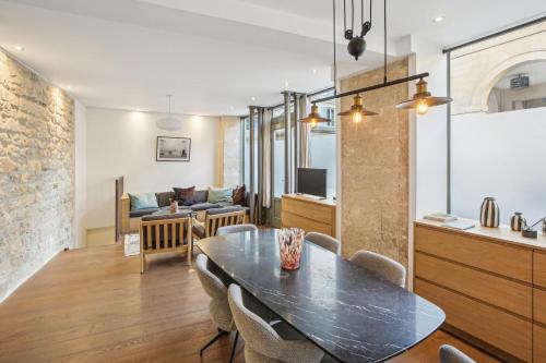 une salle à manger et un salon avec une table et des chaises dans l'établissement Luxury in the heart of St Germain A/C 3 BR outdoor, à Paris