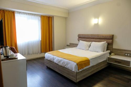 a bedroom with a bed and a large window at Anatolia Park Hotel in Kayseri