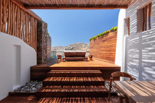 a wooden deck with a bench on a house at Mileo in Kalo Livadi