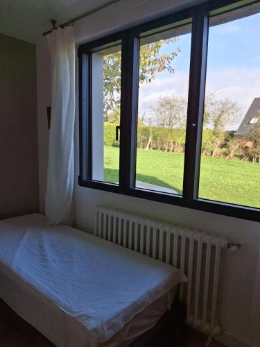 a bedroom with a bed and two windows at Kerastrobel in Crozon