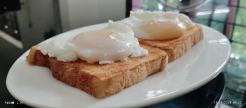 twee stukjes toast met eieren op een witte plaat bij Sebastian's Oasis in Mararikulam