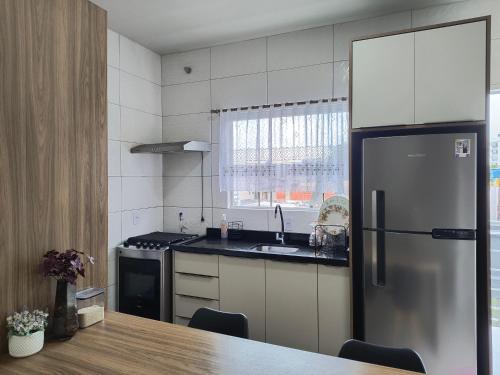 a kitchen with a stainless steel refrigerator and a sink at Casa do Vo Lelo in Penha