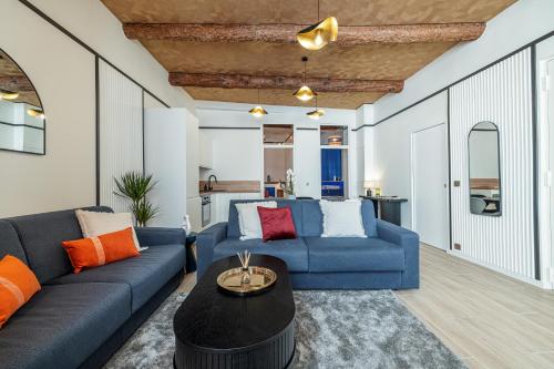 un salon avec un canapé bleu et une table dans l'établissement Le Joyau 3 pièces au coeur de Nice, à Nice