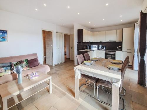 un salon avec une table et un canapé dans l'établissement Le Jardin d'Été à la Mer - T2 avec jardin, clim, parking, à Cavalaire-sur-Mer