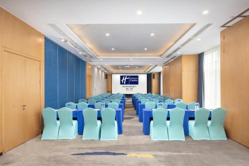 a conference room with blue chairs and a screen at Holiday Inn Express Chengdu Xindu by IHG in Chengdu