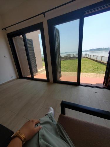 a person laying on a couch looking out at the ocean at Villa Landy in Ambohibato
