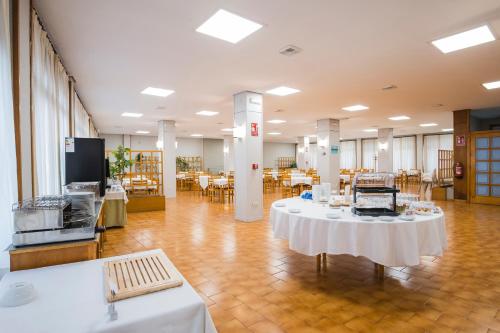 a large room with tables and chairs in it at Hotel Alda Boiro in Boiro