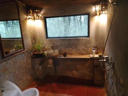a bathroom with a stone tub with a window at PuBin Spice Hills in Hòa Bình