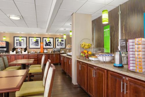 a kitchen with wooden cabinets and a table and chairs at Hampton Inn Philadelphia/Mt. Laurel in Mount Laurel