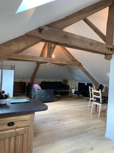 Cet appartement mansardé est doté de poutres apparentes et d'une chambre avec des chaises. dans l'établissement L'appartement du petit Bois, à Mérinchal