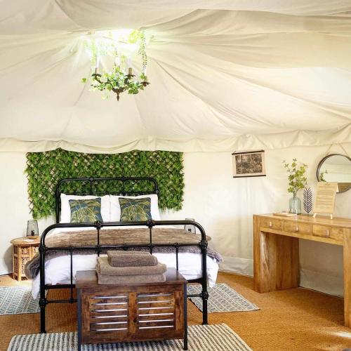 une chambre avec un lit dans une tente dans l'établissement Yurt at Le Ranch Camping et Glamping, à Madranges