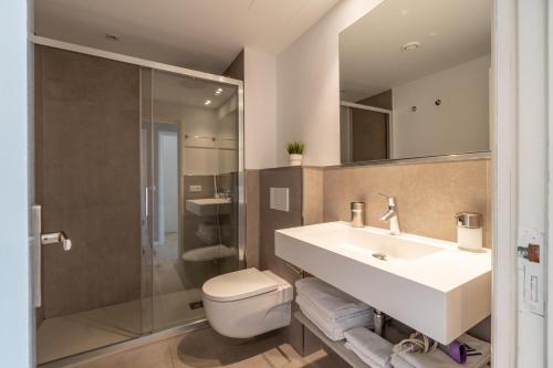 une salle de bain avec un lavabo, des toilettes et une douche dans l'établissement Ponent Cala Ratjada Apartments D, à Cala Ratjada