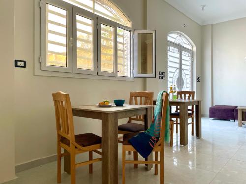 a dining room with a table and chairs and windows at Divers Home Safaga in Safaga 