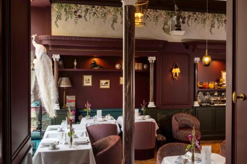 a restaurant with white tables and chairs and a dress on the ceiling at UNE AUTRE CHAMBRE in Paris